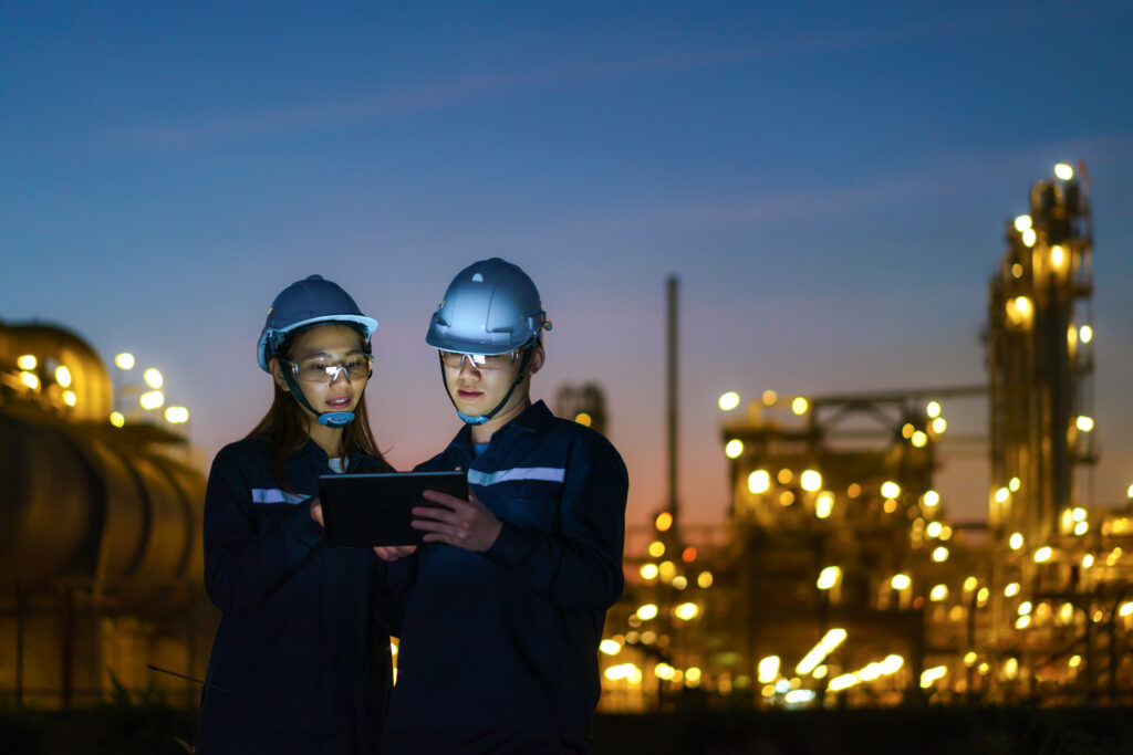 Asian engineers checking the maintenance of the oil refinery factory