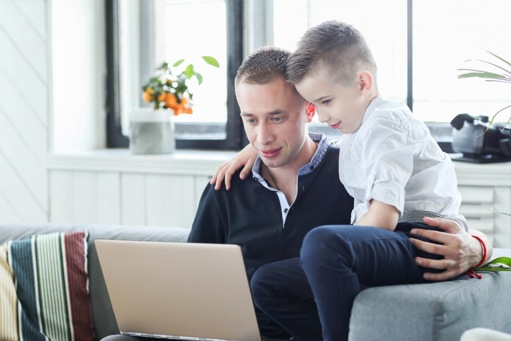 photo-of-student-taking-care-of-brother-at-home-looking-at-laptop