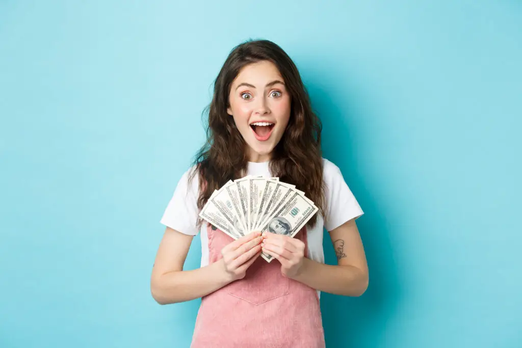 Excited girl holding dollar bills