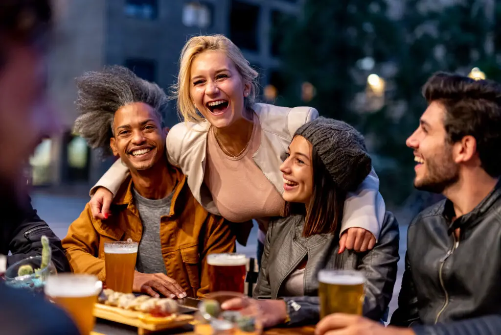 Group of friends smiling and drinking at college town brewery