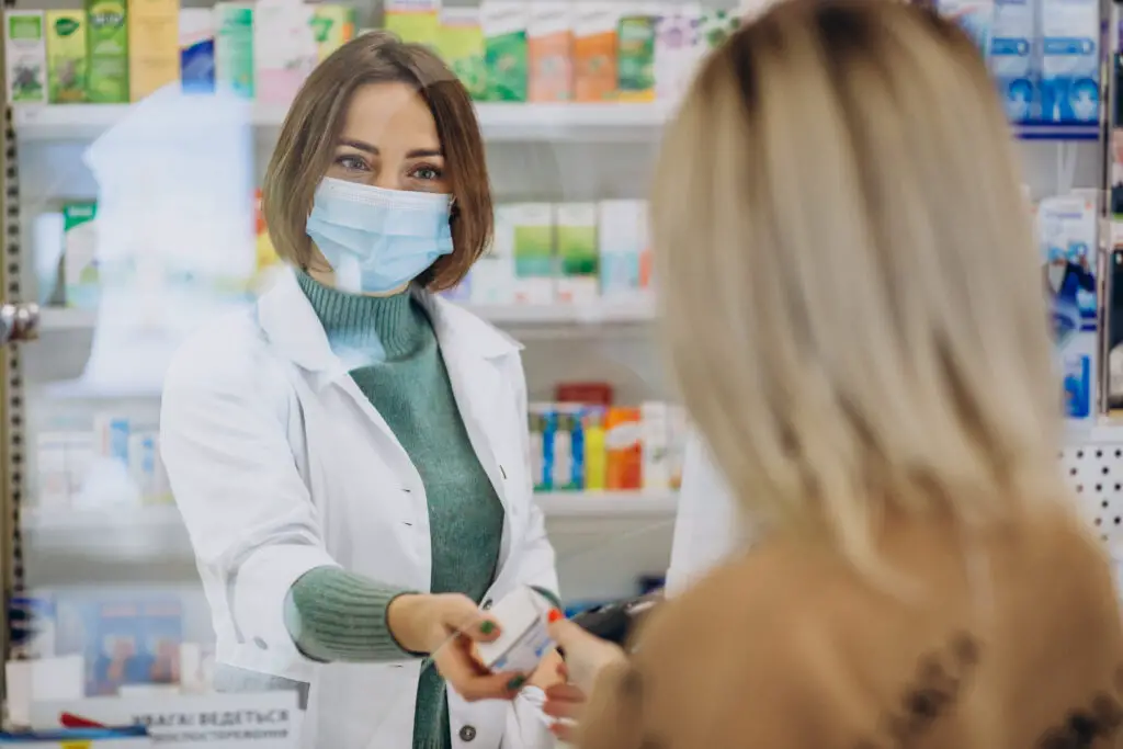 Pharmacist serving customer at drug store