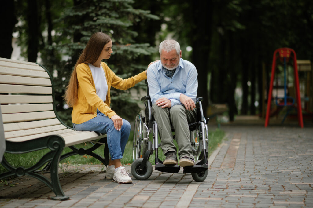 Woman takes care of old man in wheelchair