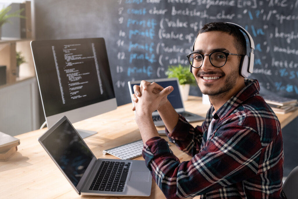 Young cheerful programmer with headphones