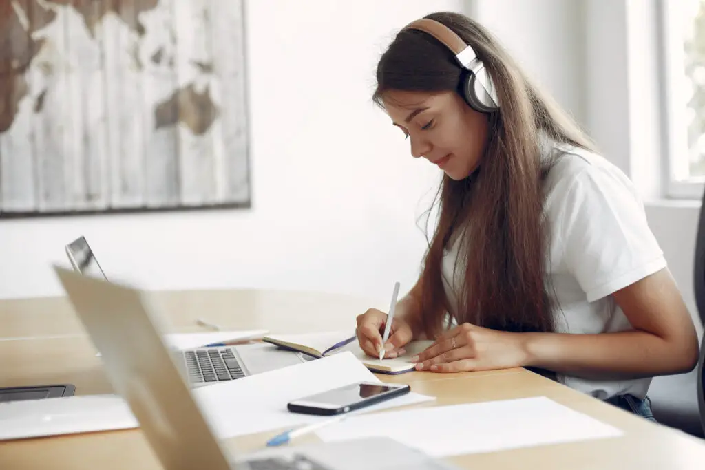 student using headphones to avoid noises that can distract from her studies