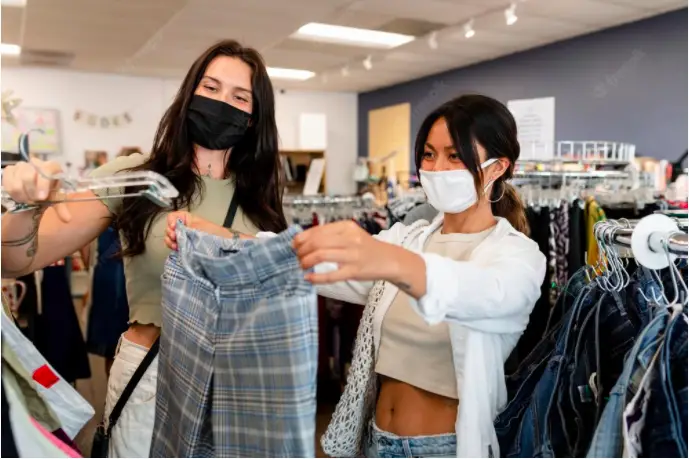 college students visiting the thrift shop to avoid fast fashion and reduce their carbon footprint