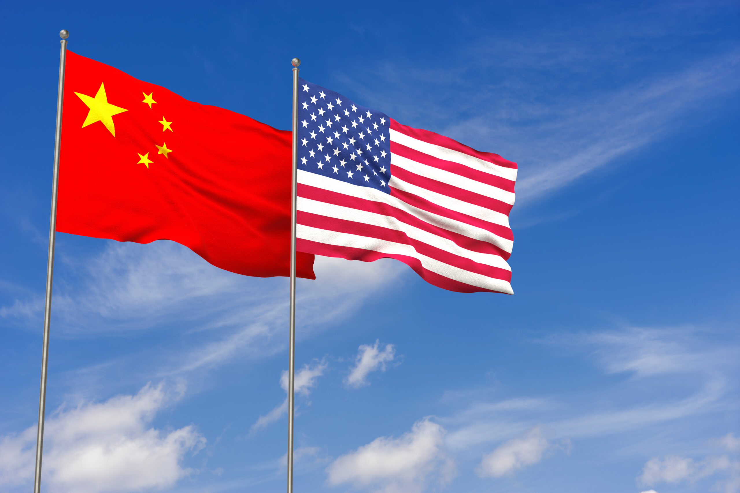 China and USA flags over blue sky background