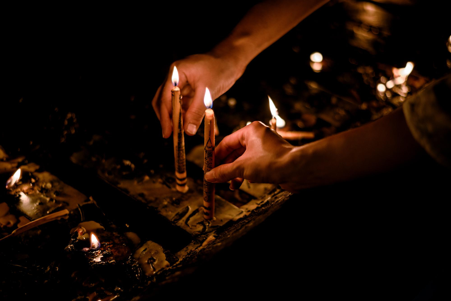 people lighting candles for a prayer vigil