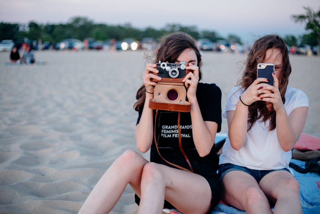 Two women taking photos on the beach