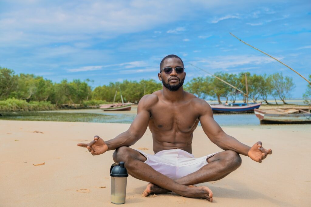 Young man meditating on the beach