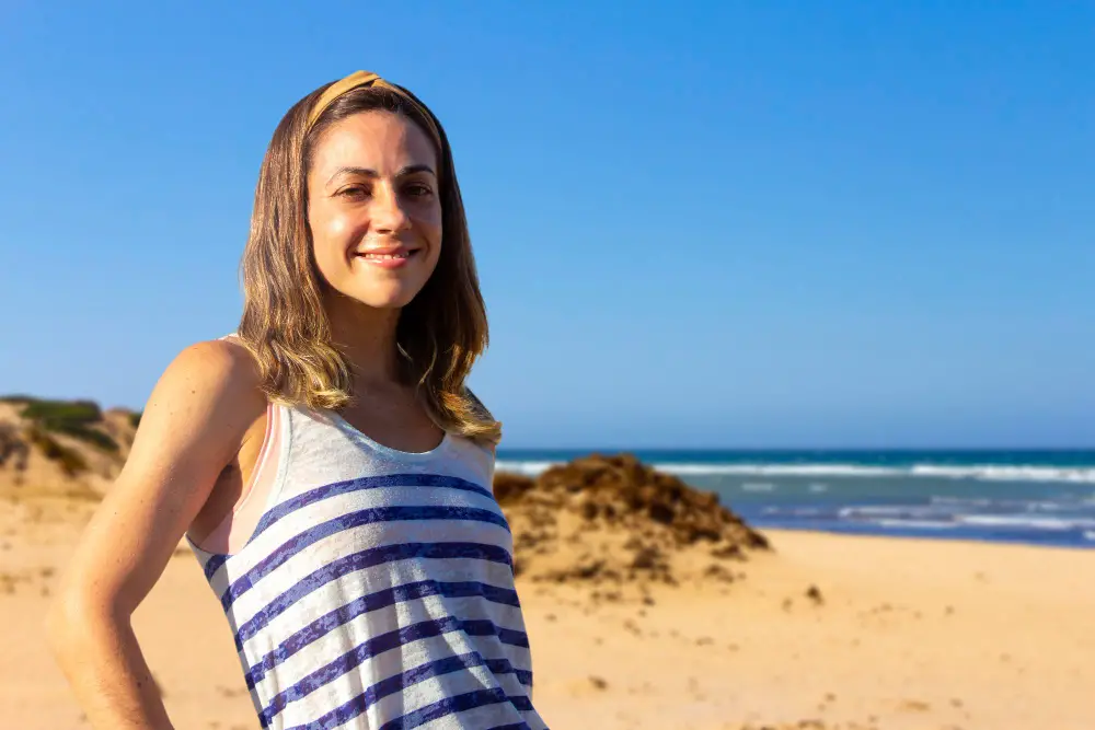 Portrait of young woman smiling on the shore of the beach