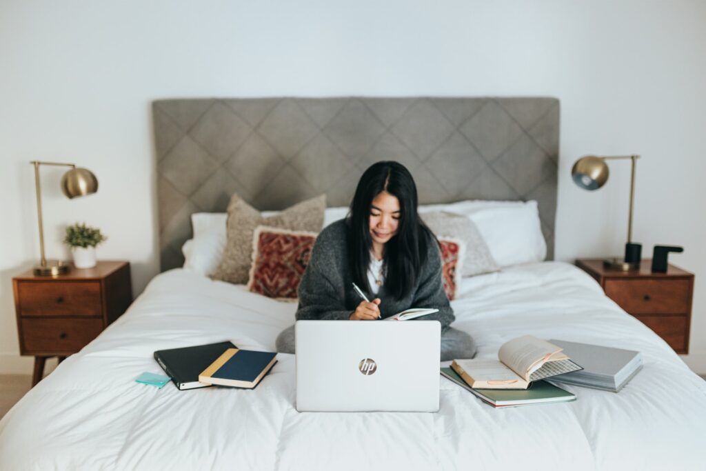 Asian college student concentrating on writing a good intro for speech