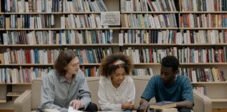 two black students and a white student sitting down and studying