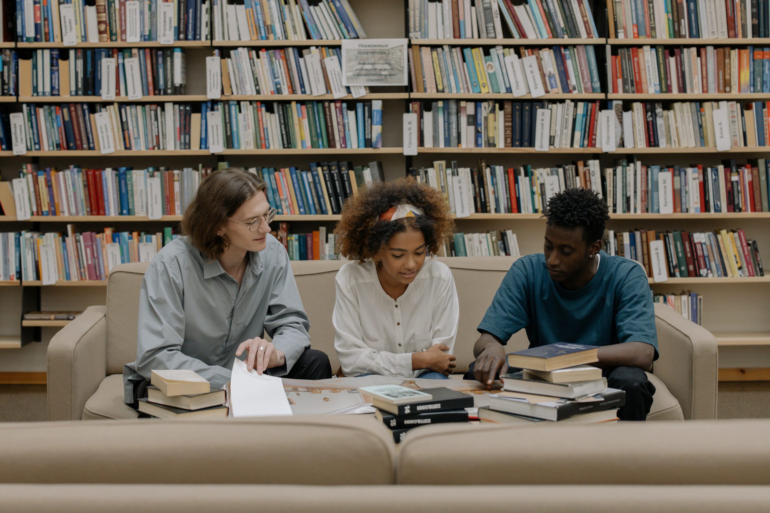 two black students and a white student sitting down and studying