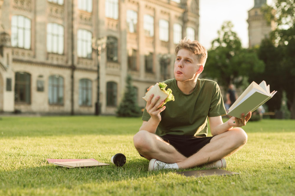 student-reading-while-eating-a-sandwich