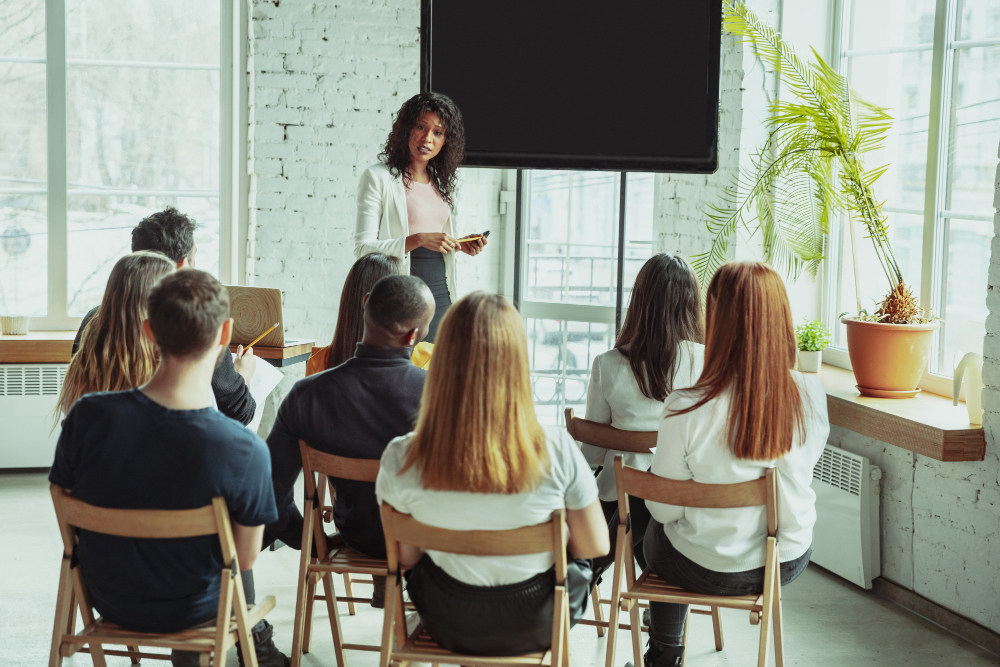 Students-sitting-in-chairs-with-teacher-in-classroom-at-ivy-league-college