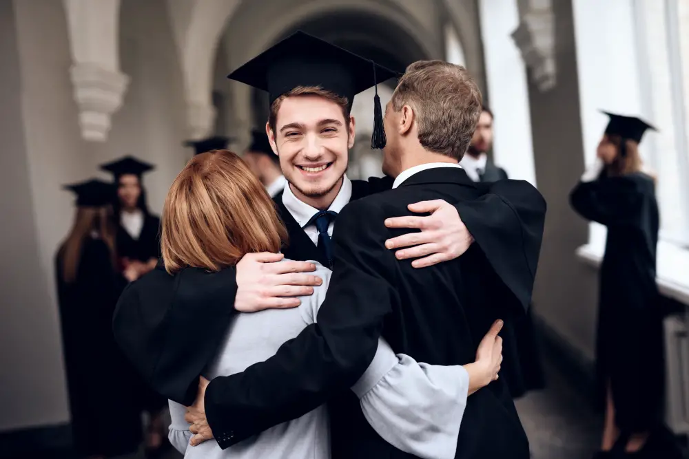 Young-male-student-hugging-family-at-graduation-at-ivy-league-college