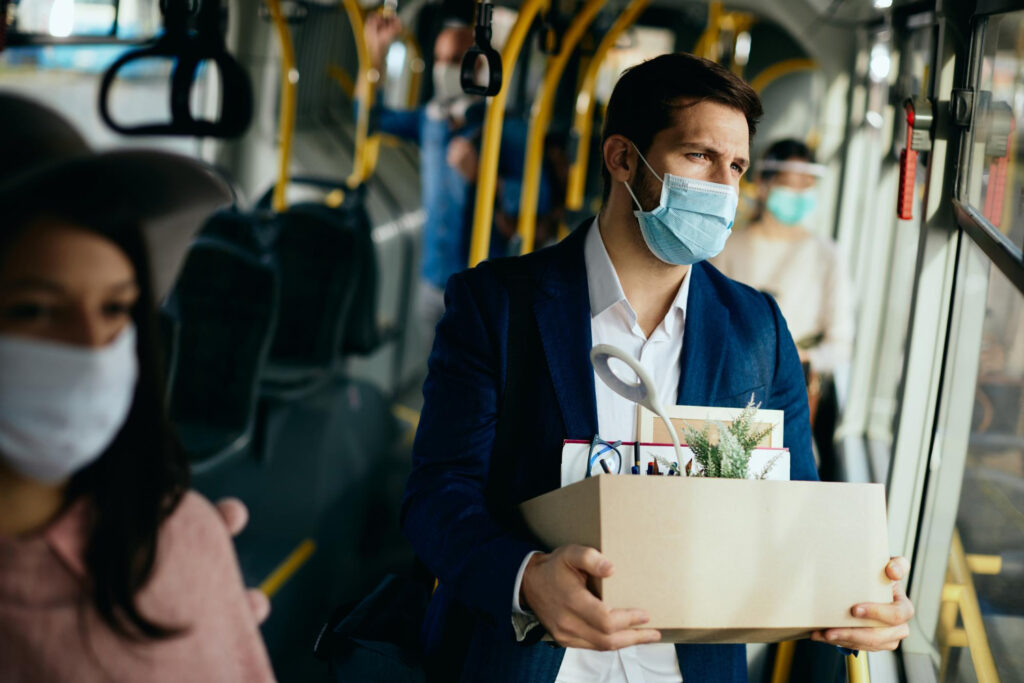 young male employee riding the bus after being terminated from work