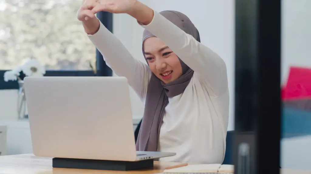 female employee wearing a hijab stretching to prepare for a long day at work