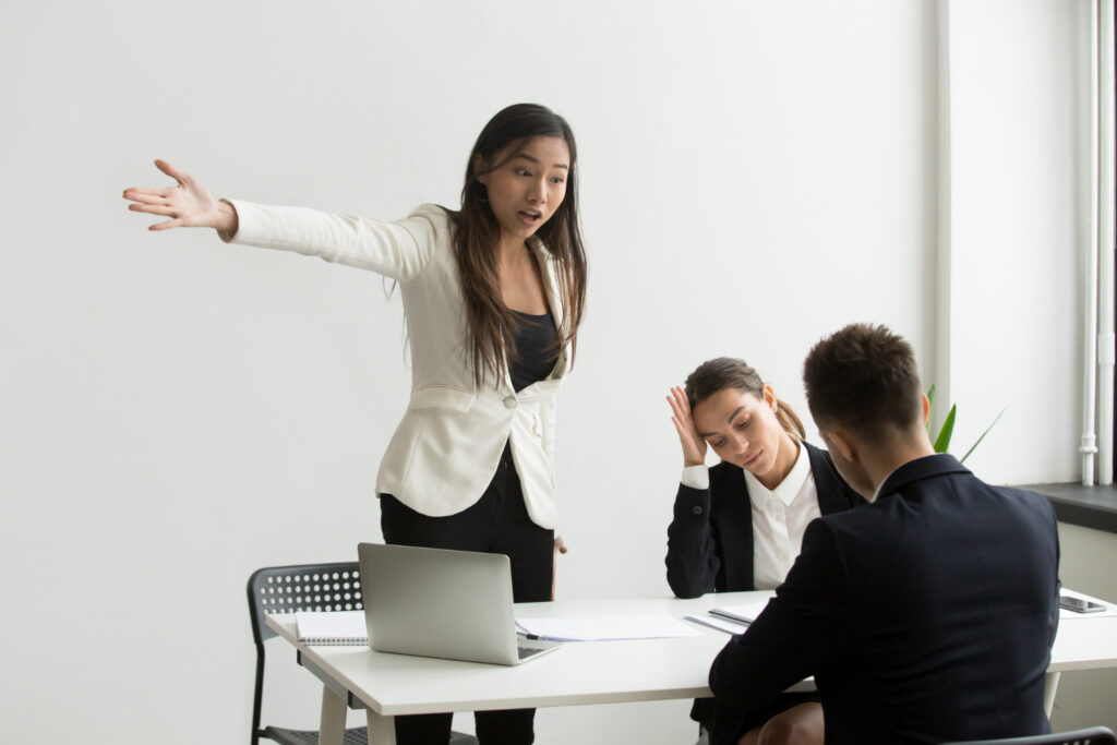 female supervisor reprimanding a young male employee for causing a crisis at work