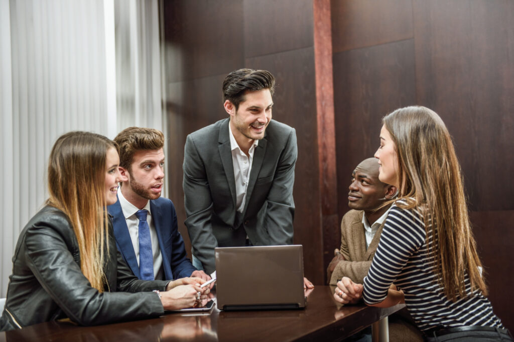 young male worker gathers his team to discuss and collaborate on upcoming presentation