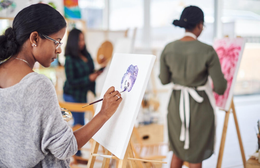 young woman painting on a canvass during her day off