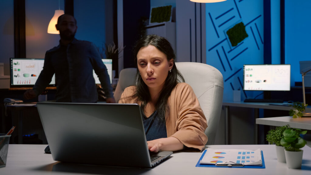 stressed woman working overtime to iron out her presentation for an upcoming meeting