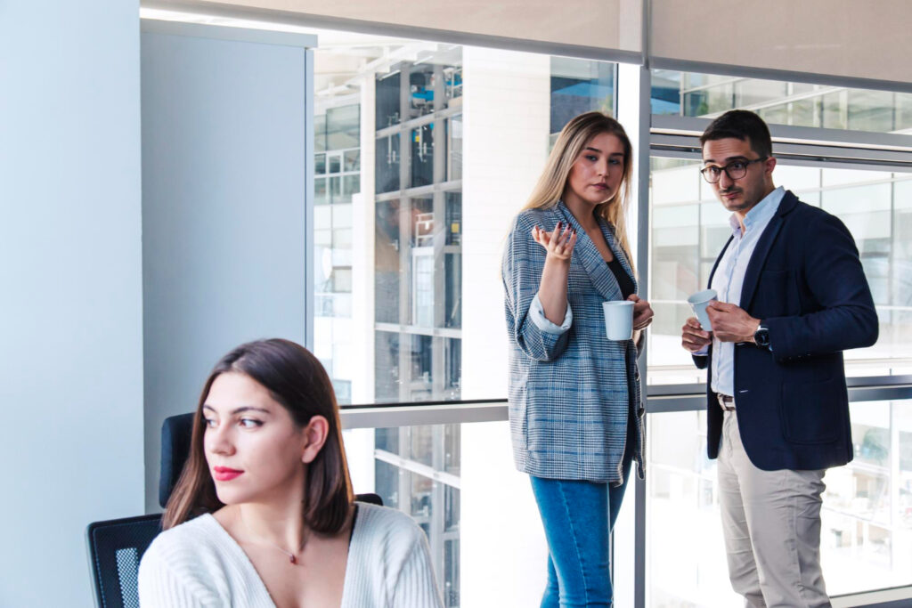 two co-workers gossiping about a new female employee