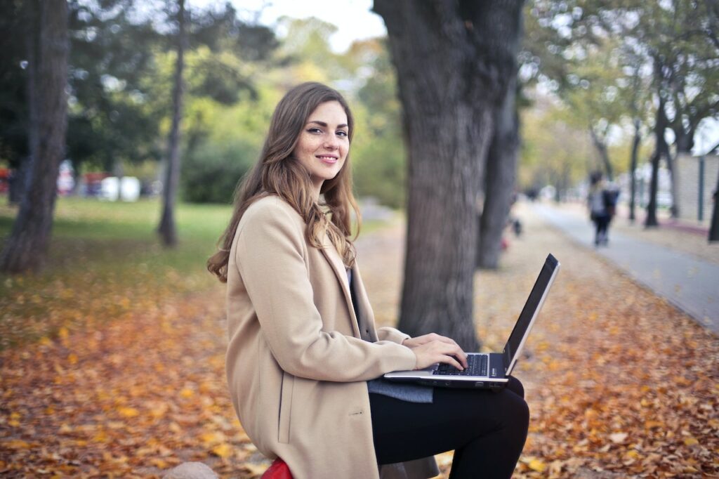 young-female-student-smiling-at-camera-on-campus-in-fall-at-ivy-league-college