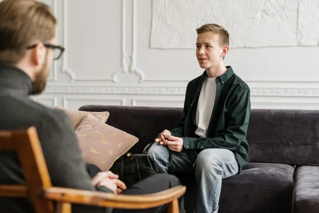 young male student in an appointment with a college mental health counselor