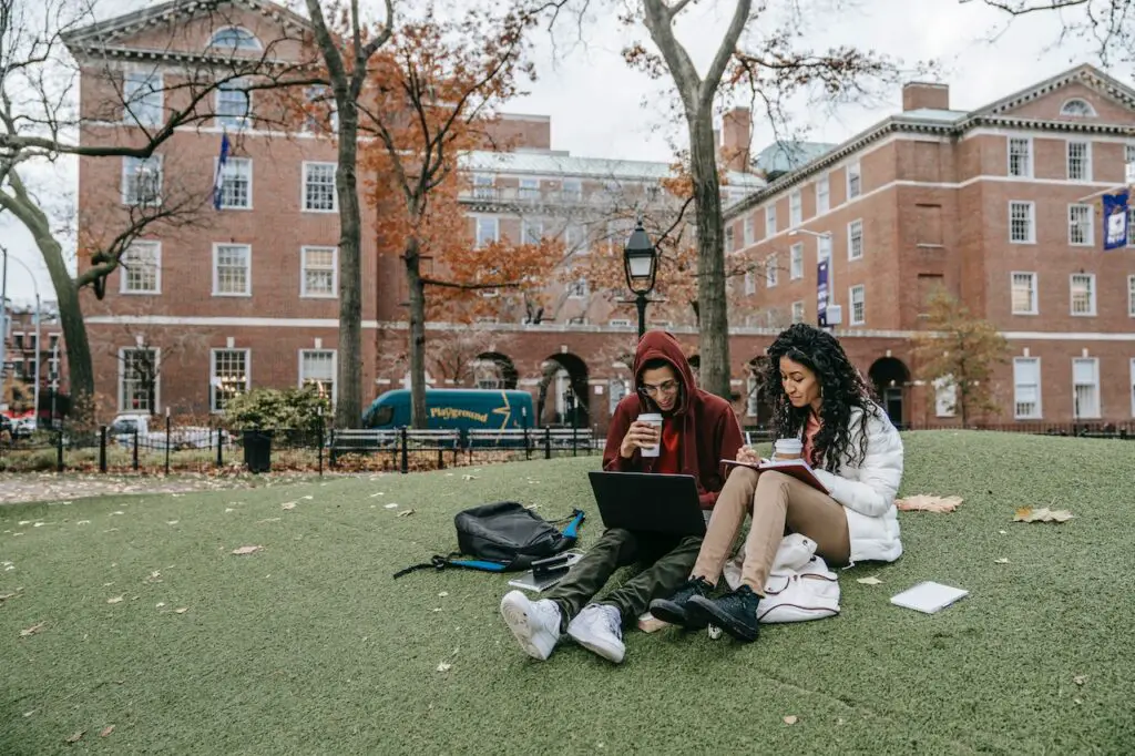 undocumented students sitting on grass at college studying after qualifying for in-state tuition