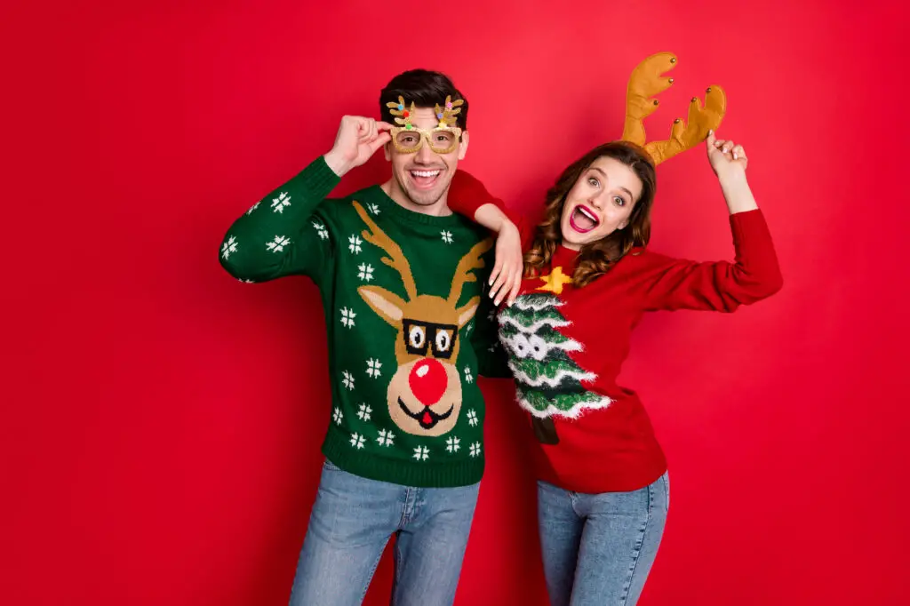male-and-female-student-wearing-sweaters-and-and-head-gear-at-an-ugly-sweater-college-party