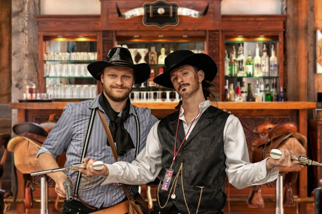 male-students-in-cowboy-attires-holding-toy-guns-at-a-western-college-party