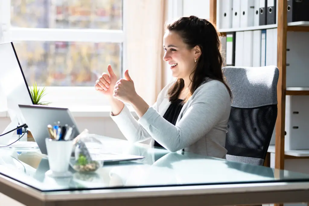 a-female-professor-talking-to-her-virtual-class-through-a-laptop-on-top-of-a-desk