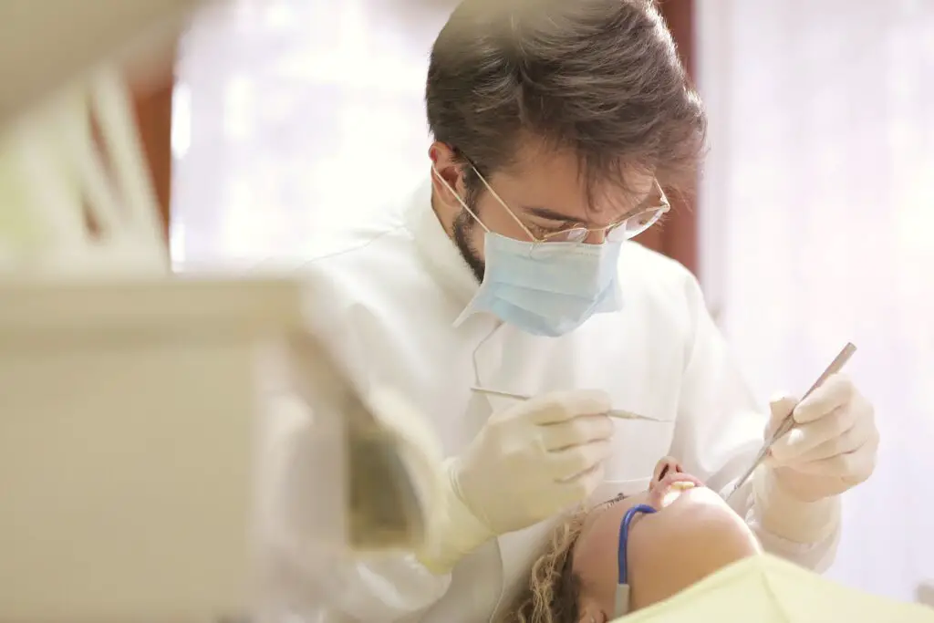 Dental student checking for tooth decay and oral problems in a patient