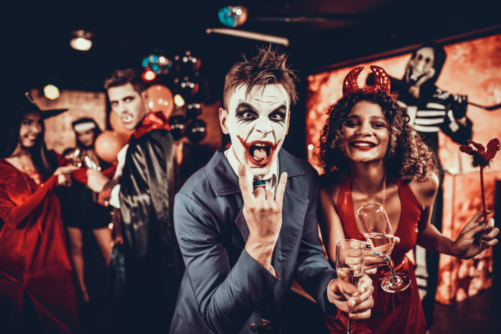 female-and-male-students-dressed-as-spooky-characters-with-drinks-at-college-party