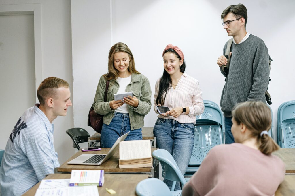 Five college students discussing a research paper as part of their contract grading in a non-traditional school system