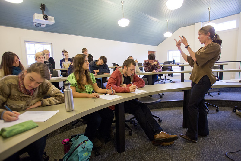 Instructor discussing to a small group of college students following Bennington College's non-traditional grading system