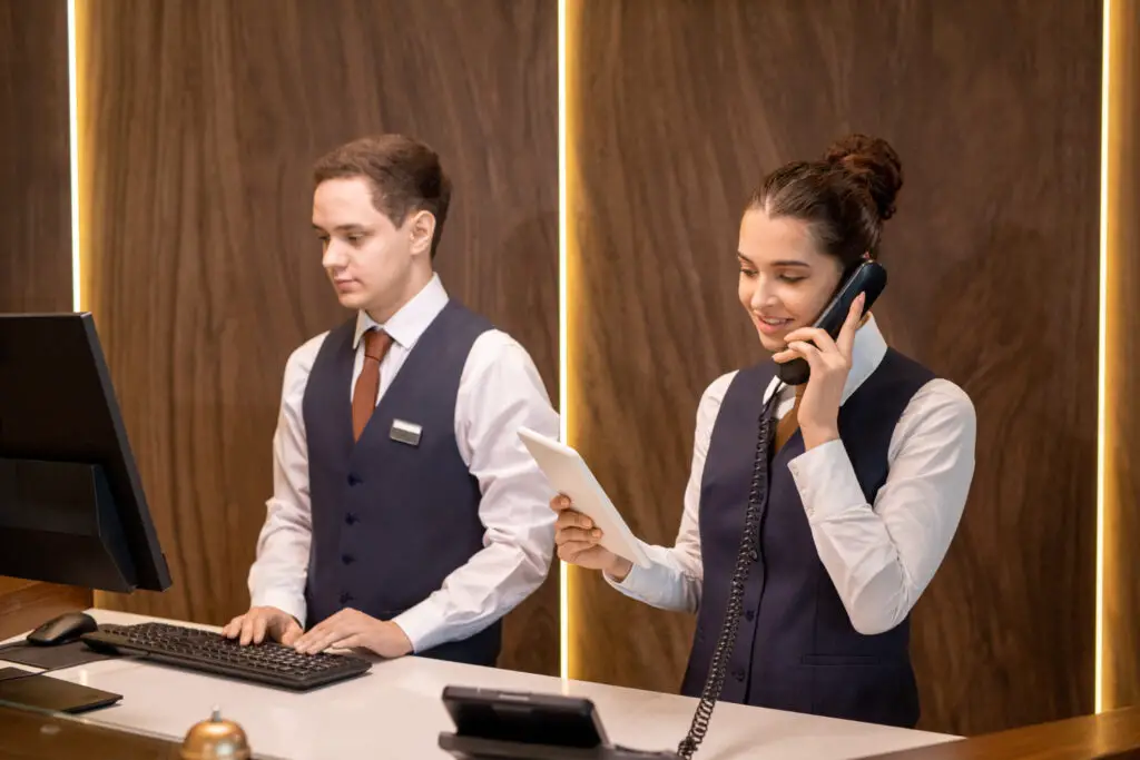 Two college students as part-time hotel receptionists working at the front desk