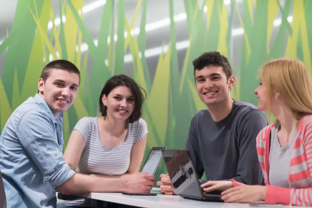 Four computer science students smiling during a Hackathon event at Cornell