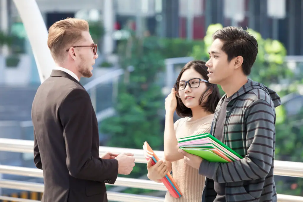 Company recruiter visiting a computer science college talking to two students during the industry fair