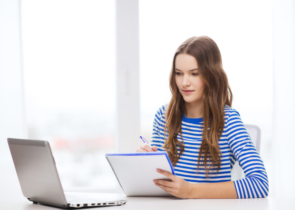 female-college-student-wearing-a-striped-long-sleeved-shirt-listing-several-college-options-for-her-FAFSA-application