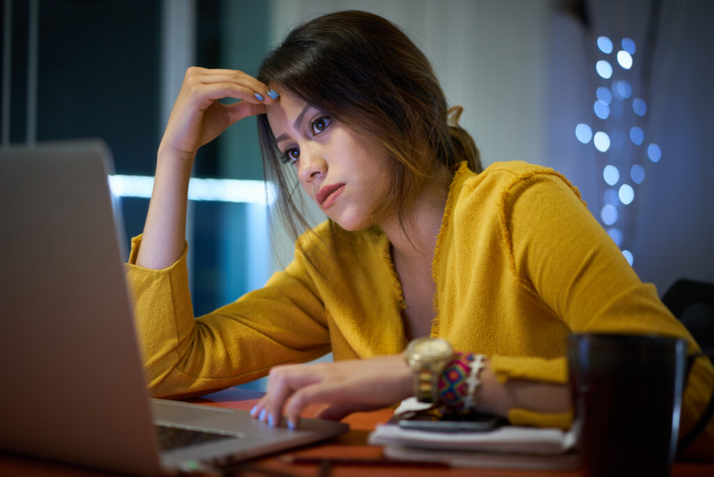 female-college-student-wearing-yellow-shirt-staring-at-her-laptop-to-make-sure-she-doesn't-leave-unanswered-questions-on-her-FAFSA-application