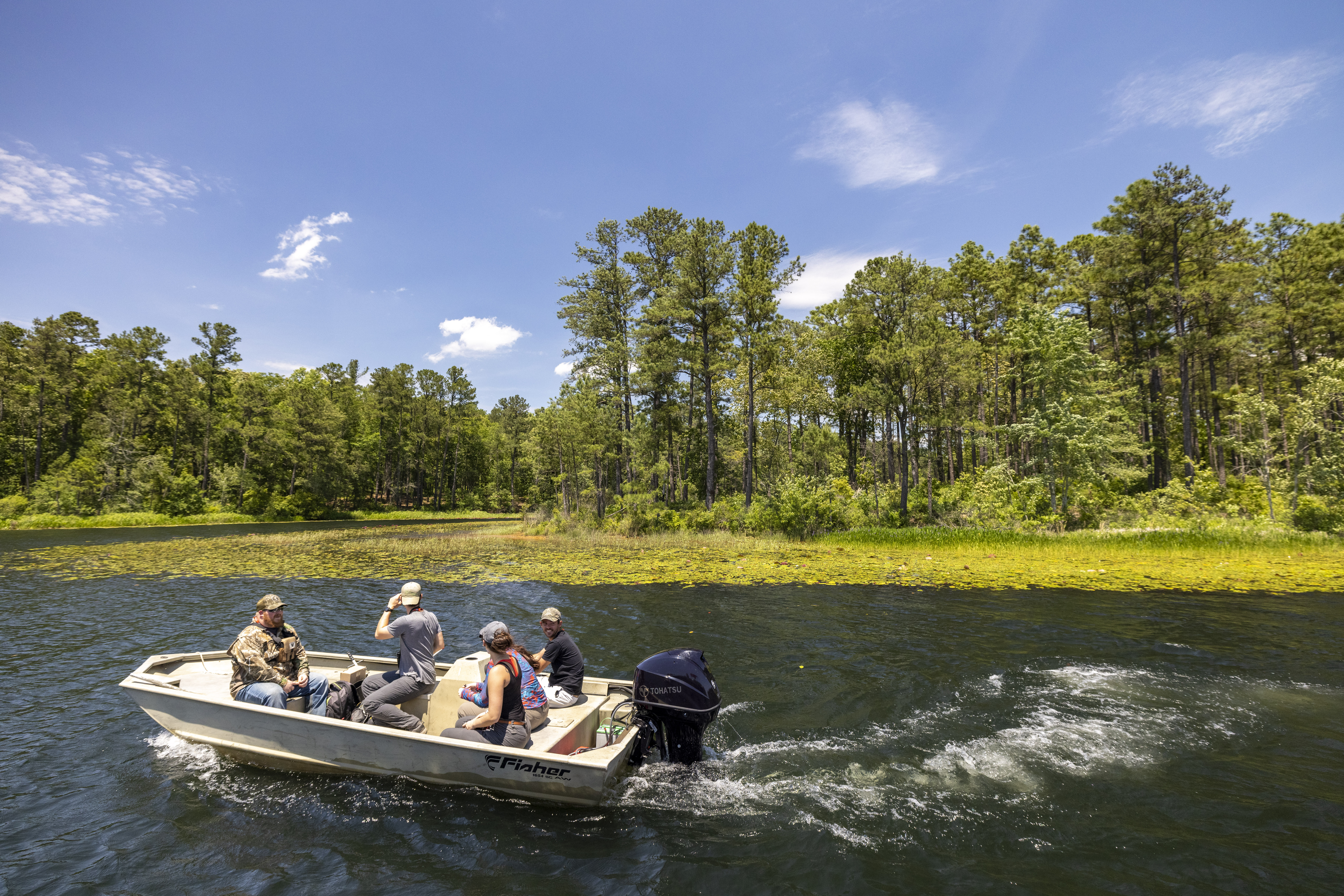 Five University of Georgia's forestry majors riding on a boat toward another part of the forest to collect plant samples
