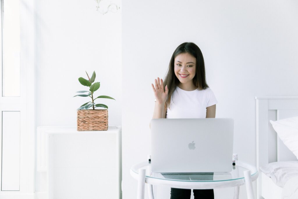 Female applicant waving goodbye with a smile to an online job interview