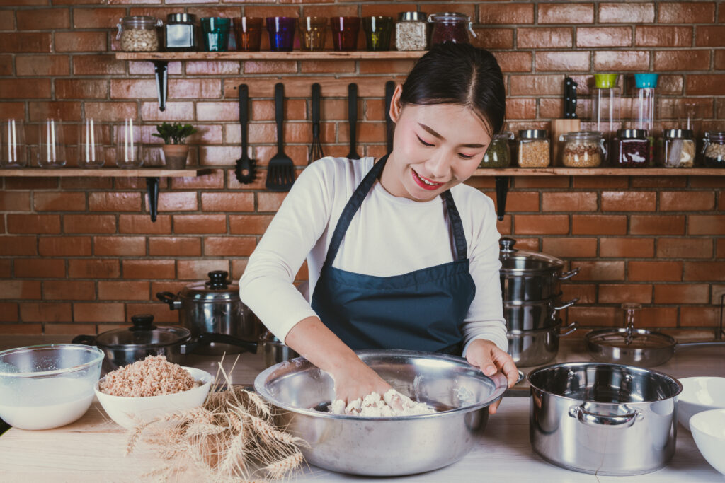 A female student of Chicken University, one of the weirdest college names worldwide, preparing the chicken batter in the school kitchen 