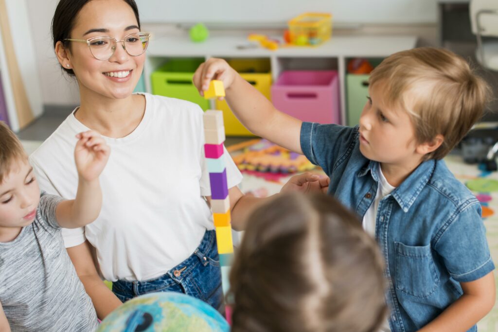 A smiling female college student teaching and looking after kids at daycare after joining volunteering opportunities at college