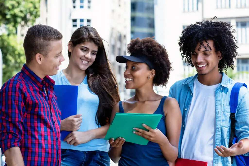 a diverse group of male and female international college students studying outdoors