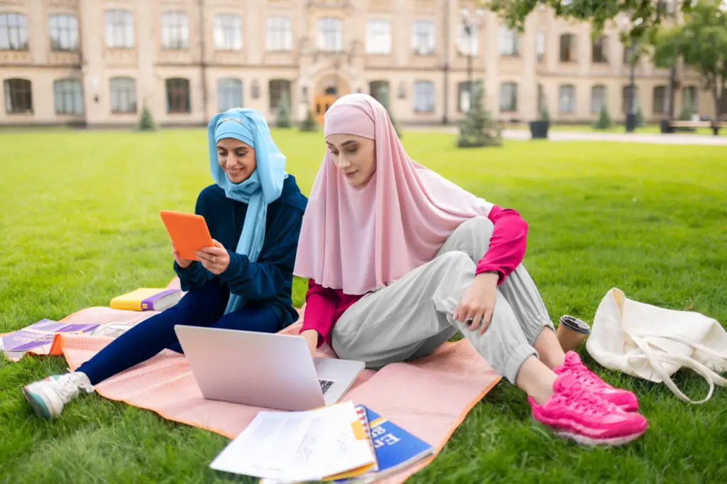 International female college students wearing hijab studying in the field