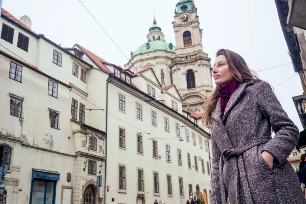 A female college traveler on the lookout for art installations along Prague's streets  