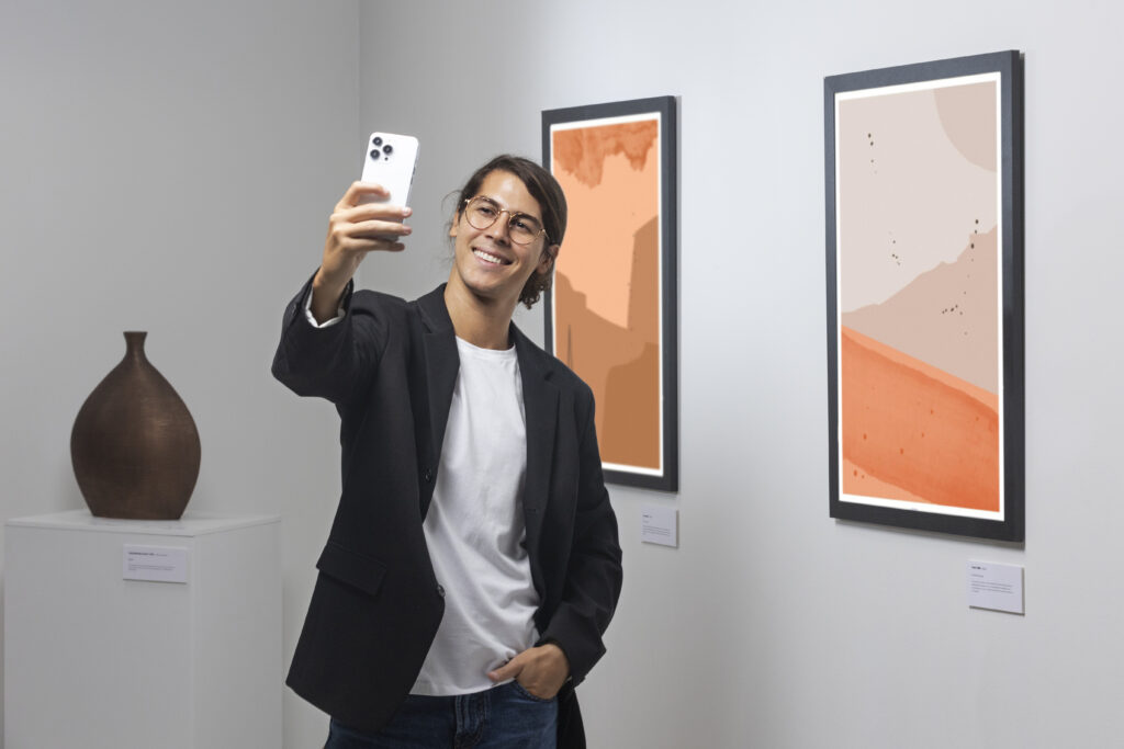 A male college student taking a selfie in one of Raleigh's museums during his vacation trip
